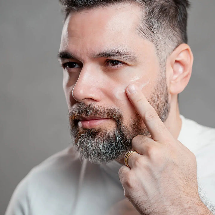 Homem passando hidratante facial Major com vitamina C no rosto