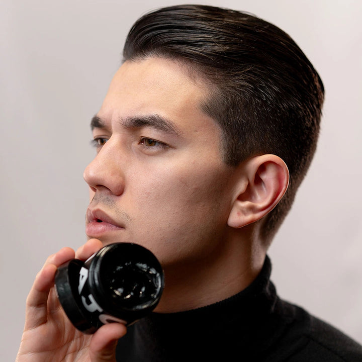Homem com cabelo penteado usando pomada modeladora Major efeito úmido, acabamento brilhante sofisticado e fixação de alta performance.