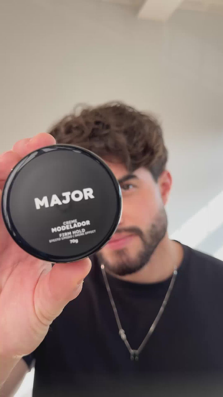 Homem segurando pomada modeladora Major efeito úmido para cabelo masculino